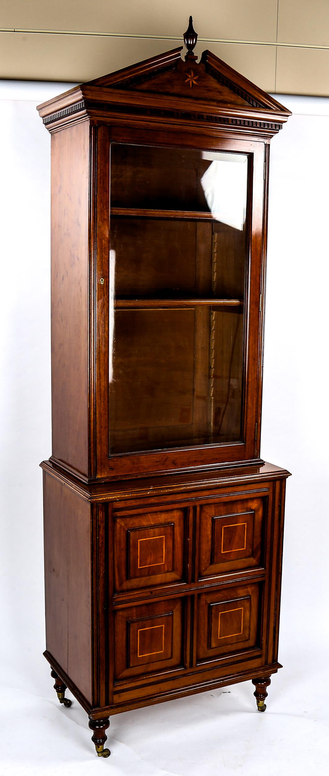 A late Victorian narrow mahogany bookcase, with fielded panelled cupboard below, width 66cm,