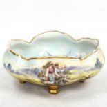 A Vienna porcelain bowl with hand painted decoration, depicting country women, on gilded feet, width