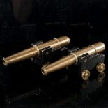 A pair of bronze barrelled table cannons, on painted wood carriages with brass wheels, barrel length