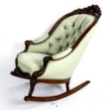 A Victorian fireside rocking chair with carved walnut frame and buttoned upholstery