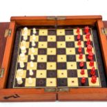 A 19th century mahogany travelling chess set, with carved red and white stained ivory chess