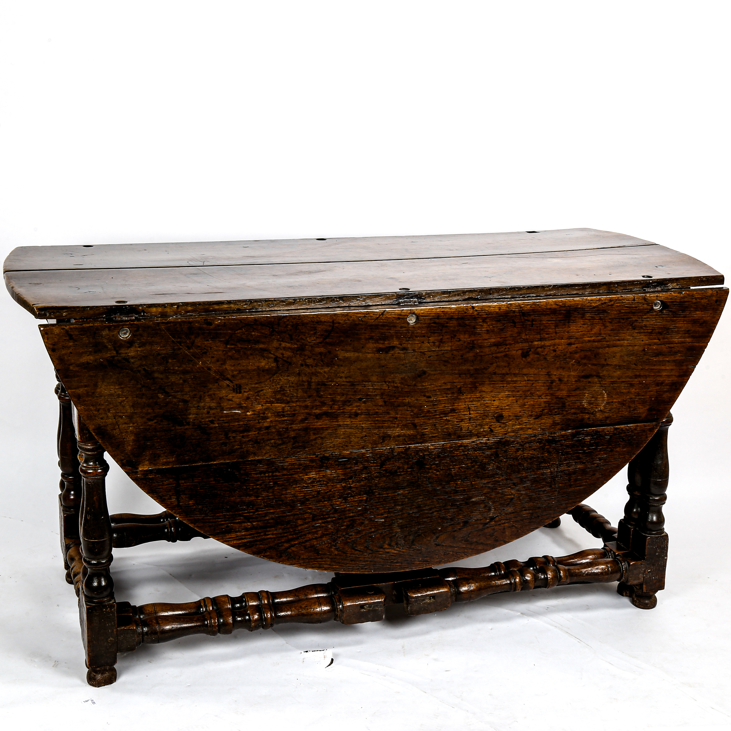 A large 17th/18th century oak gateleg dining table, on ring-turned legs with two frieze