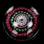 Millefiori glass paperweight with rings of red and green alternating canes, diameter 6.5cm
