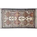 An Antique handmade Afghan wool rug, geometric floral design with Arabic script, 205cm x 121cm