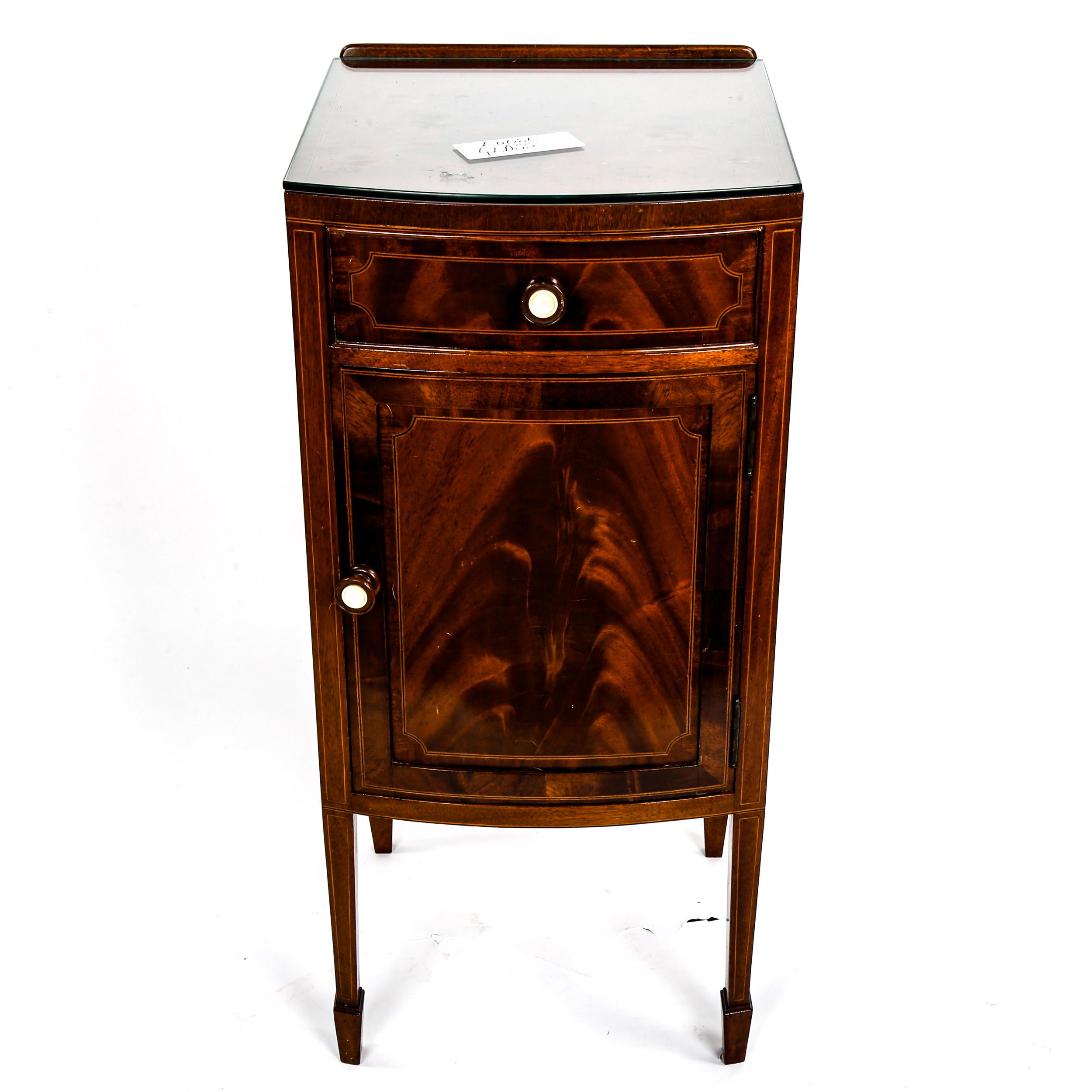 An Edwardian mahogany bow-front bedside cupboard, with frieze drawer and ivory-mounted handles,