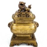 A Chinese polished bronze incense burner and cover on stand, with Dog of Fo knop and engraved