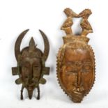 An African patinated verdigris bronze mask, height 30cm, and a carved wood Tribal mask (2)