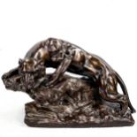 A bronze patinated plaster sculpture, lioness on a rock, mid-20th century, length 46cm A few