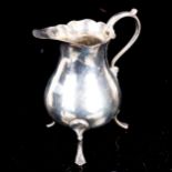 A George III silver cream jug, bulbous form with scalloped rim and 3 feet, by William Kersill,