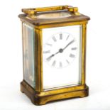 A brass-cased carriage clock, white enamel dial with Roman numeral hour markers, blued steel hands