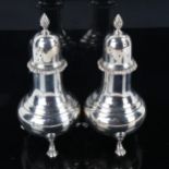 HARRODS - a pair of Elizabeth II silver pepperettes, baluster form with spiral finial and