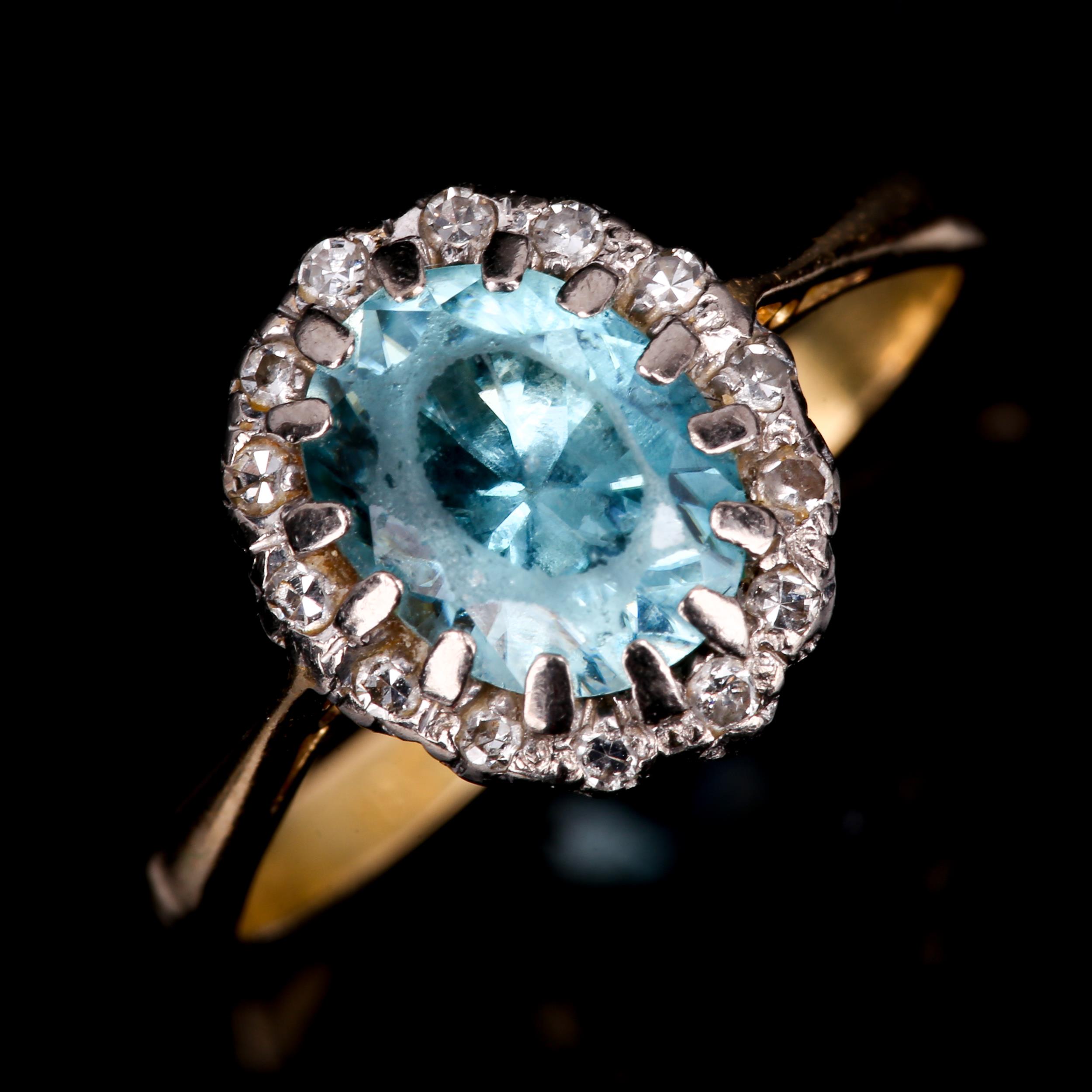 An 18ct gold blue zircon and diamond oval cluster ring, set with oval mixed-cut zircon and single-