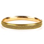 A late 20th century 9ct gold Etruscan style hinged bangle, cannetille and rope twist decoration,