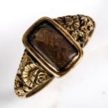 A William IV woven hair panel mourning ring, unmarked yellow metal settings with floral shoulders