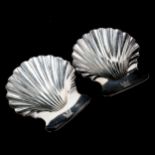 A pair of George III silver butter shells, with three shell feet and engraved crests, by Robert