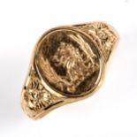 A late 20th century 9ct gold seal signet ring, engraved lion head crest with floral shoulders,