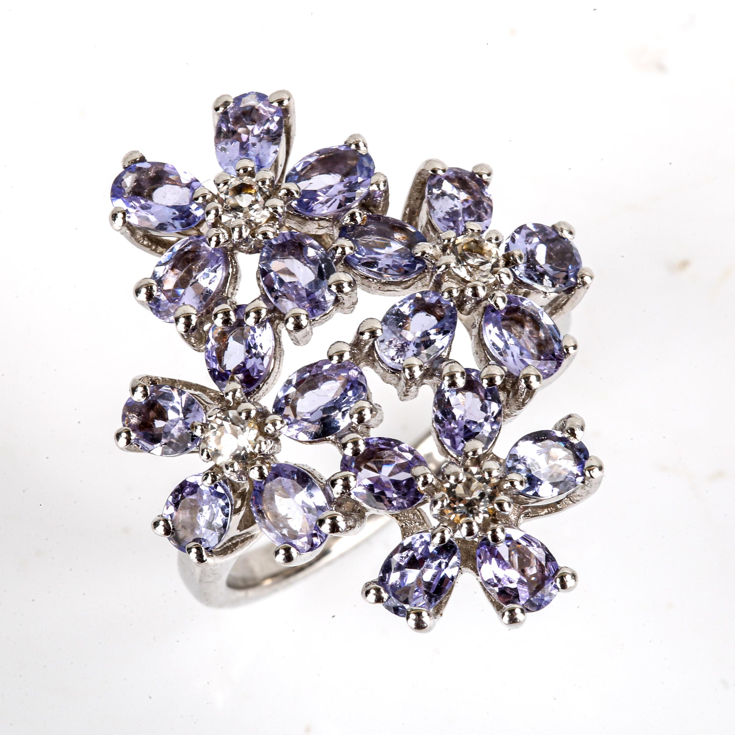 A large modern sterling silver tanzanite and cubic zirconia flowerhead ring, set with oval-cut