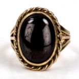 An unmarked gold cabochon garnet dress ring, rope twist surround with closed back settings,