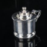 An Art Deco George V silver mustard pot, cylindrical form with stepped lid and blue glass liner,