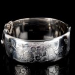 A mid-20th century silver hinged bangle, engrave floral decoration, by E Lilley & Co, hallmarks