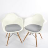 CHARLES EAMES for Vitra, a pair of DAW armchairs, with white shell and grey padded seat, on maple