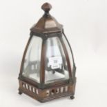 An early 20th century patinated brass framed table lantern, with original curved bevel-glass panels,