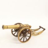 A brass table cannon on wheeled carriage, barrel length 18cm, probably late 19th century