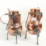 A pair of 19th century copper lidded flagons on iron feet, with iron swing handles, height 38cm