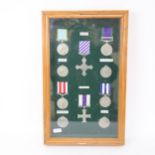 A framed set of pewter/lead copy war medals and crosses, case 40cm x 25cm