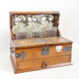 A Victorian oak tantalus with hinged front compartments, single drawer below, original square cut-