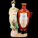 A bottle of Chinese Kaoliang Hung Chiew wine in sealed porcelain bottle, flanked by a figure of a