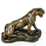 A bronze patinated spelter figure of a lioness, signed Cartier on the base, length 29cm