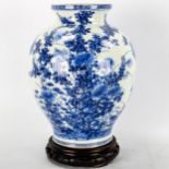 A Chinese blue and white porcelain vase with painted detailed floral design, attached wood base,