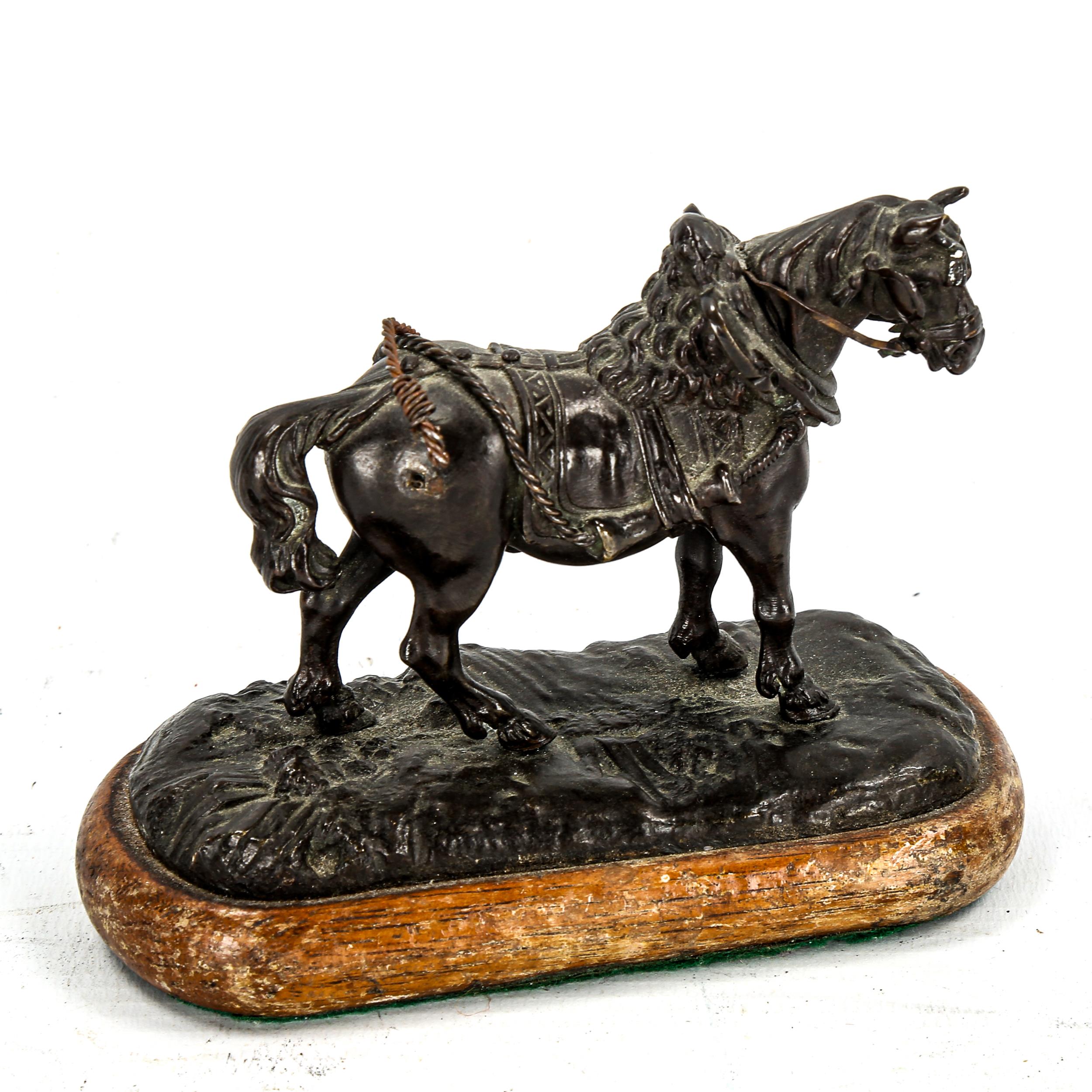 A small 19th century patinated bronze sculpture of a saddled horse, unsigned, length 11cm