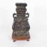A Chinese patinated bronze 2-handled vase, Hu, on shaped wood plinth, overall height 22cm