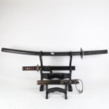 2 Samurai style swords on fitted stand, longest 90cm, and a dagger in sheath, on display stand