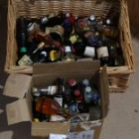 A wicker hamper containing a quantity of miniature liquor bottles, including liqueurs and Whisky,