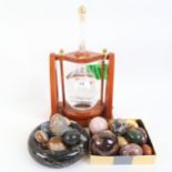 A group of hardstone eggs, veined marble bowl, bottle of Via Roma Distillati Grappa