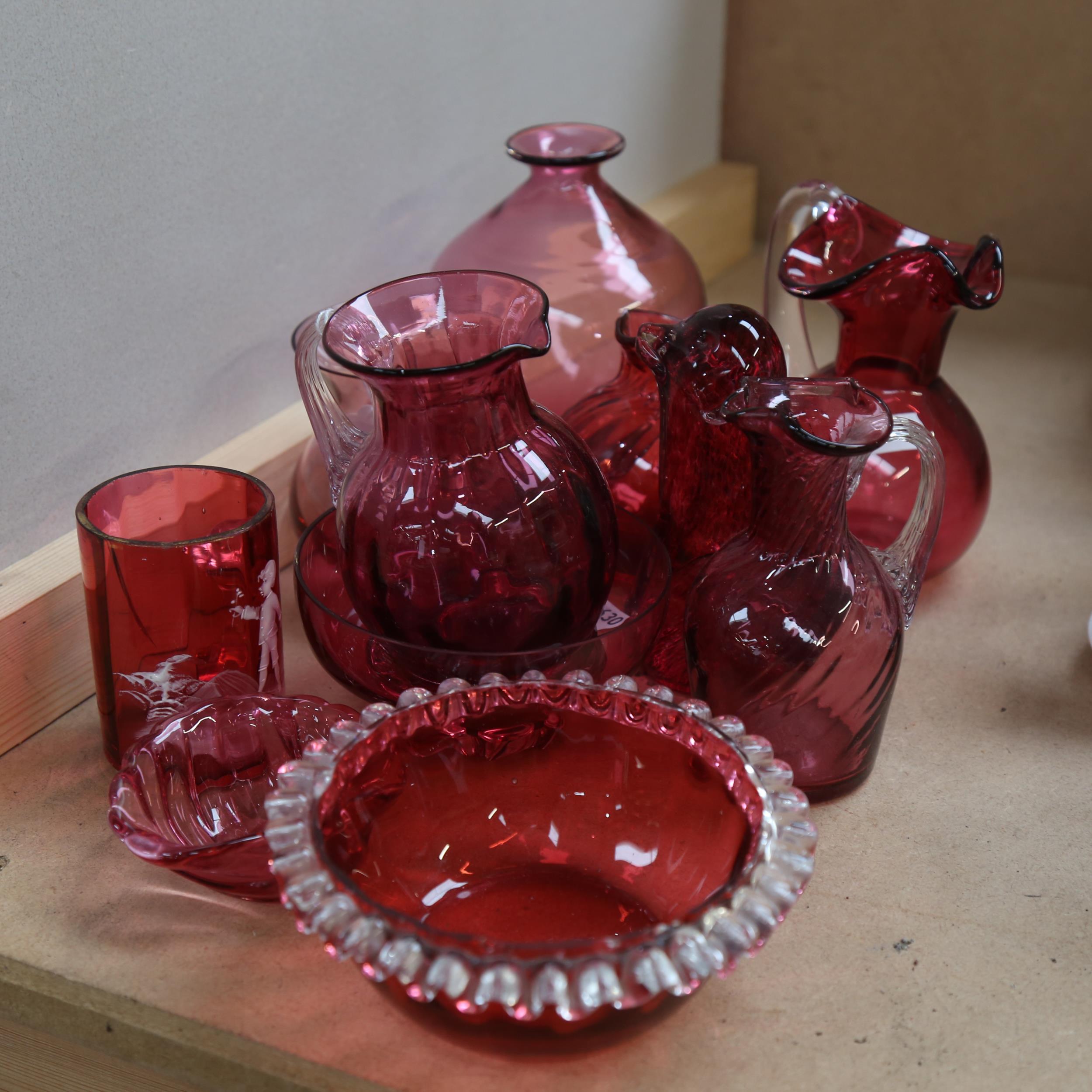 A group of cranberry glass jugs, Wedgwood paperweight, 12cm etc