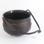 A cast-iron cauldron, with carrying handle, overall width 38cm