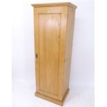 A pine hall cupboard with single panelled door, and key, W64cm, H181cm, D49cm