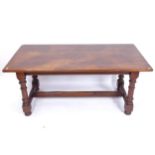 An oak refectory dining table, on turned baluster legs and bun feet, with H-shaped stretcher,