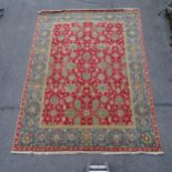 A red ground Persian design carpet, floral symmetrical decoration, 365cm x 276cm Carpet is in good