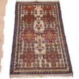 An Antique handmade Afghan wool rug, geometric floral design with Arabic script, 205cm x 121cm