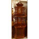 A modern mahogany standing carved and pierced corner unit, with cupboard base and single drawer,