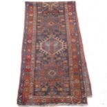 A red and blue ground Afghan design runner (worn), 332cm x 82cm