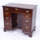 A George III mahogany kneehole writing desk of small size, with recessed alcove cupboard, and fitted