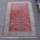 A red and green ground Persian design carpet, with floral symmetrical pattern, 423cm x 290cm