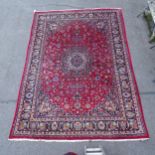 A red ground Persian design Mashad carpet, 395cm x 285cm Carpet is in good overall condition,