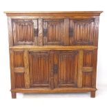 A large oak cupboard, with linenfold carved panelled doors, on stile legs, L160cm, H150cm, D50cm